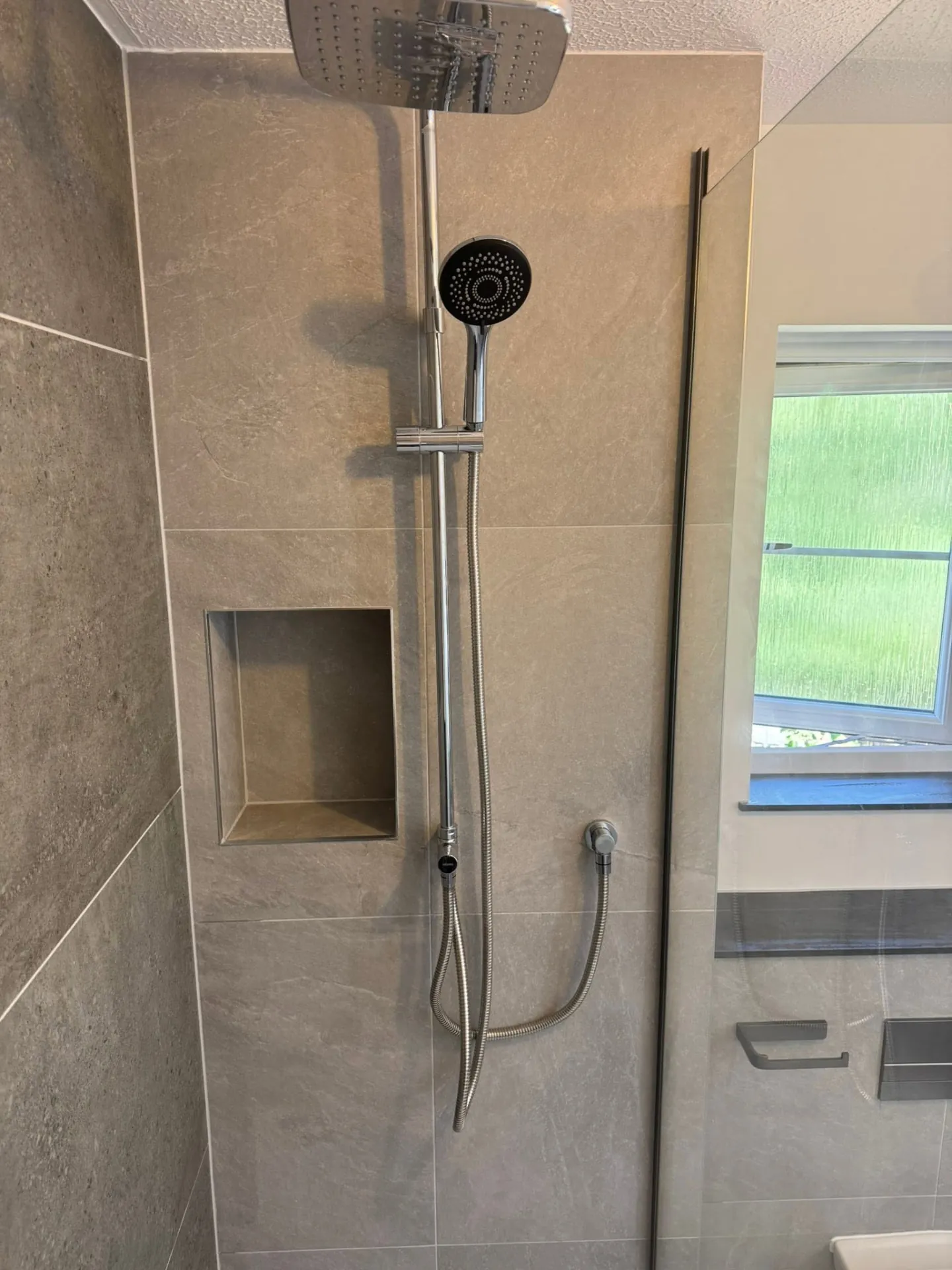 Bathroom installation by Space B Tiling: shower and recessed tiled niche in stone-effect tiling