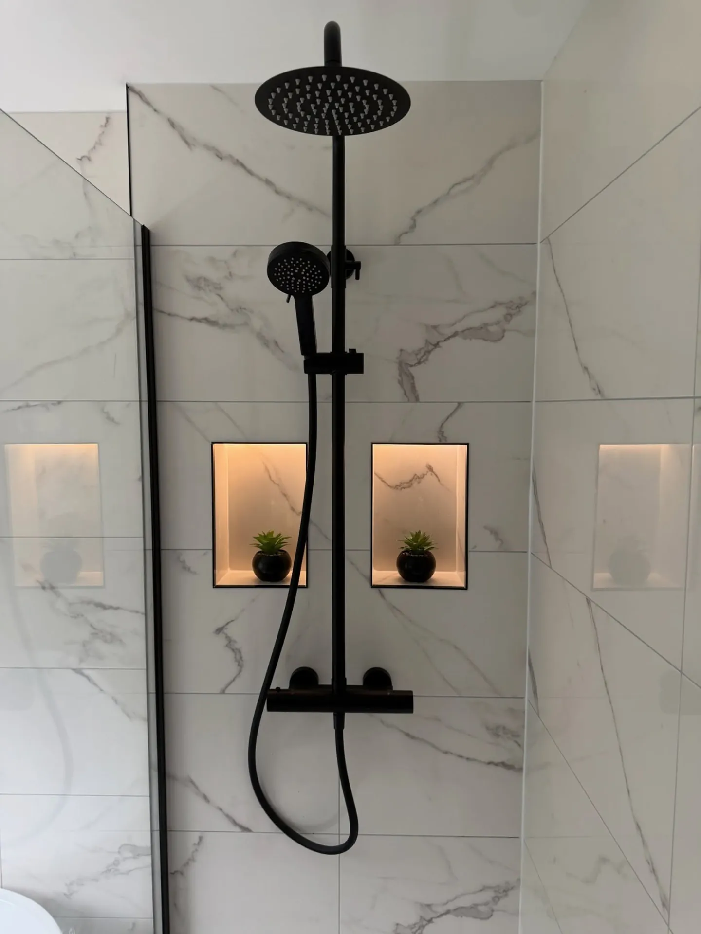 Bathroom installation by Space B Tiling: black shower set with lit tiled niches