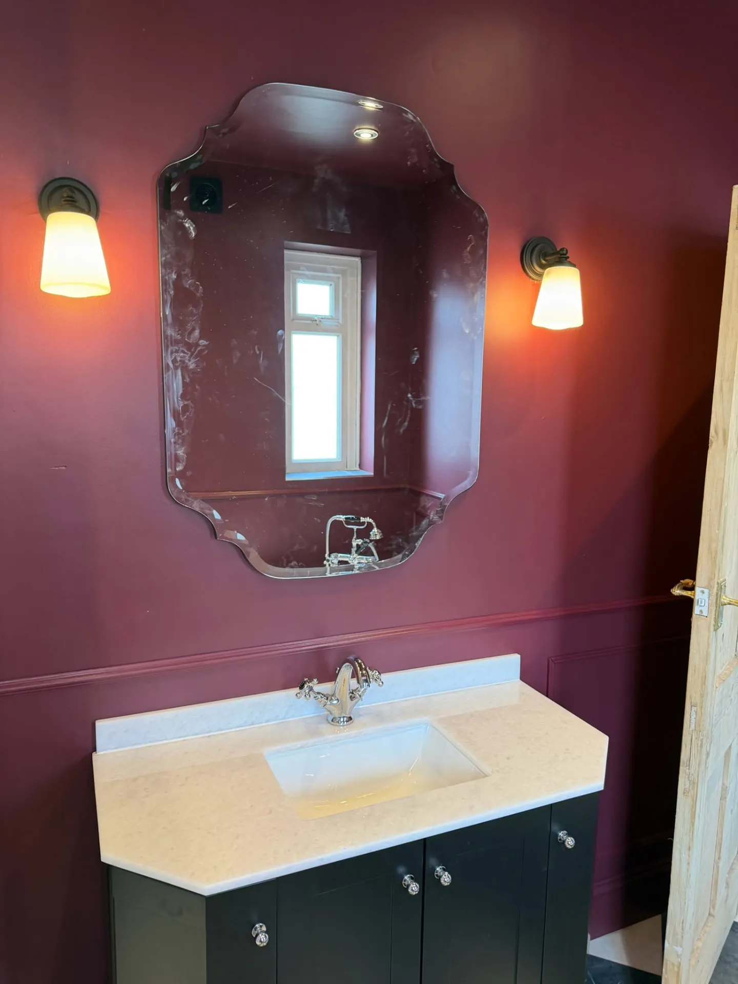 Bathroom installation by Space B Tiling: traditional vanity with wall lights on burgundy walls