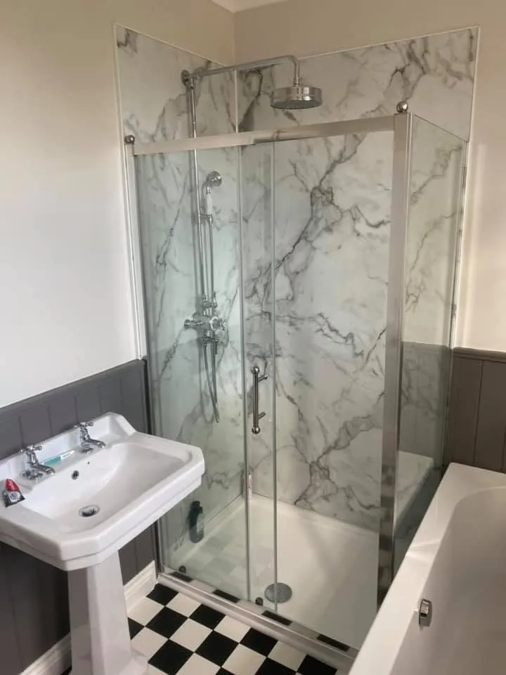 Bathroom installation by Space B Tiling: quadrant shower enclosure with marble-effect wall panels