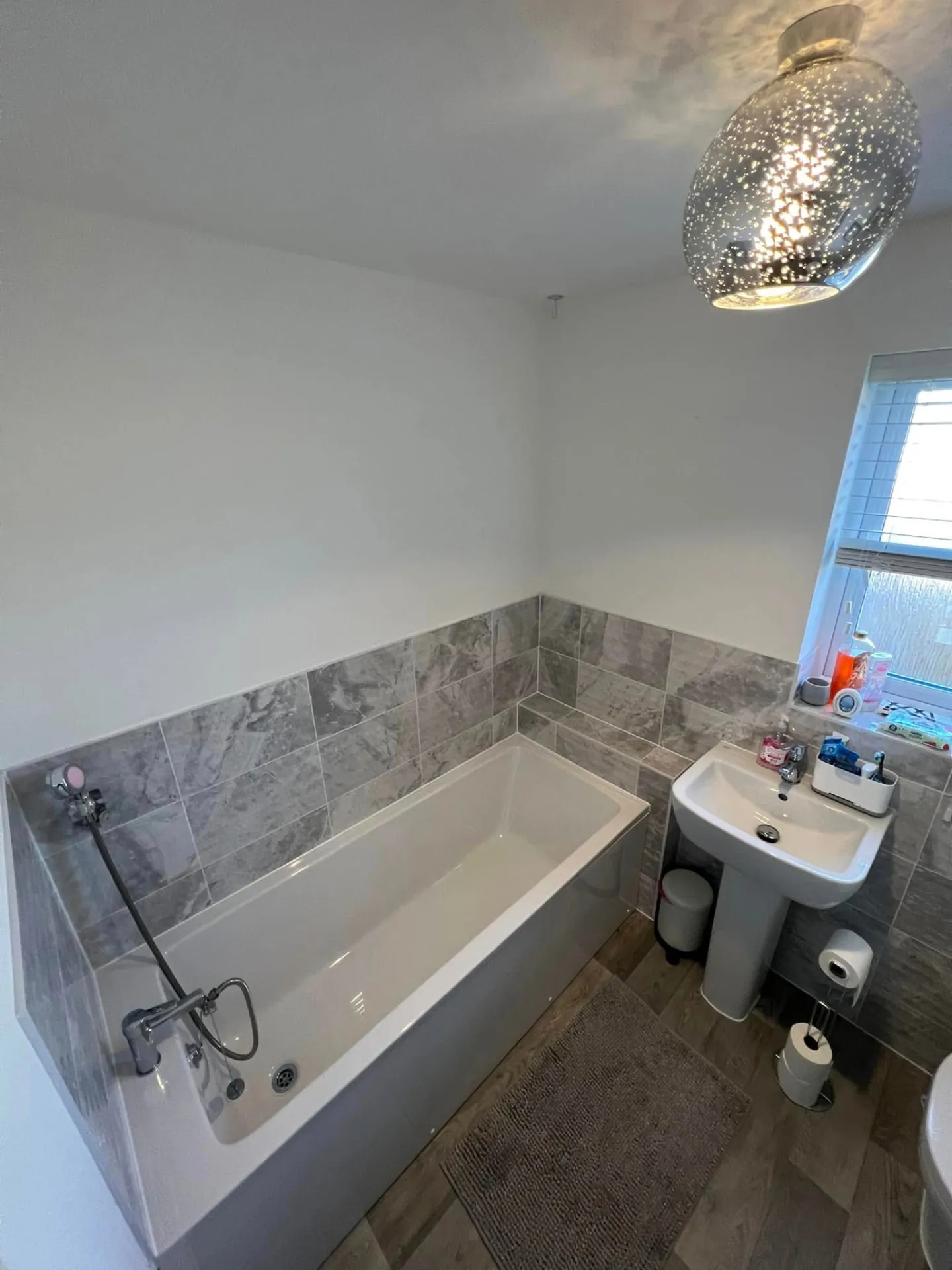 Bathroom installation by Space B Tiling: bath and pedestal basin with grey wall tiles