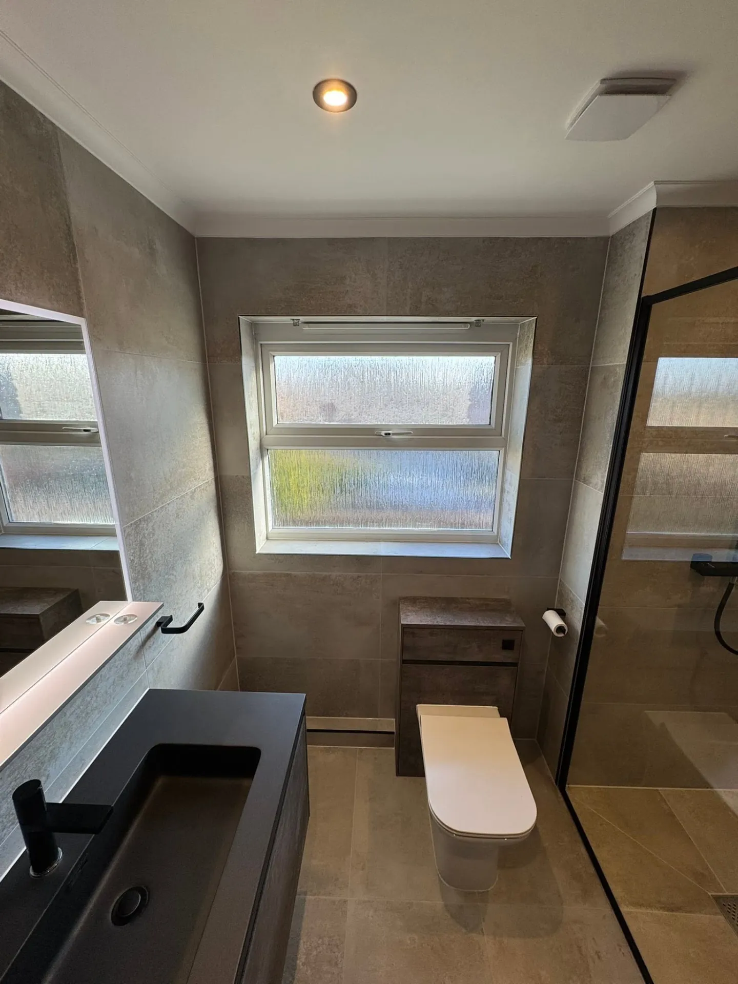 Bathroom installation by Space B Tiling: taupe-tiled bathroom with shower, toilet and vanity