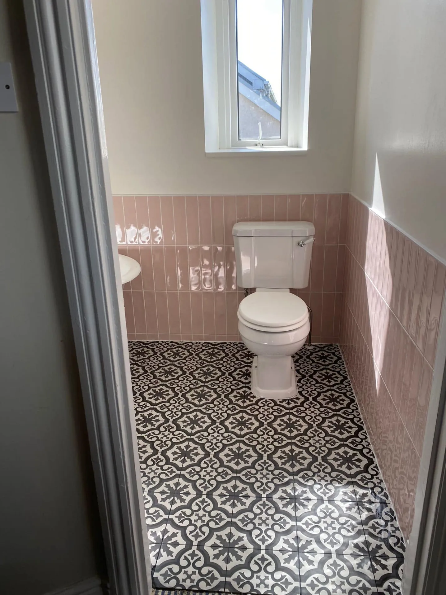 Bathroom installation by Space B Tiling: pink wall tiles and geometric patterned floor