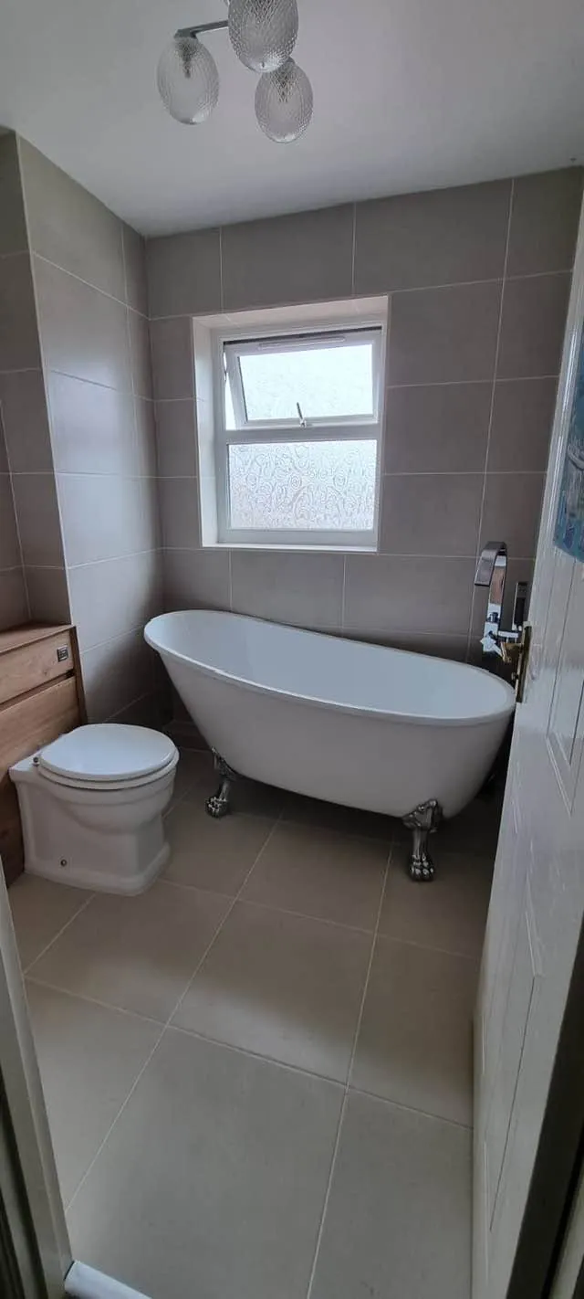 Bathroom installation by Space B Tiling: freestanding bath and toilet with neutral tiles