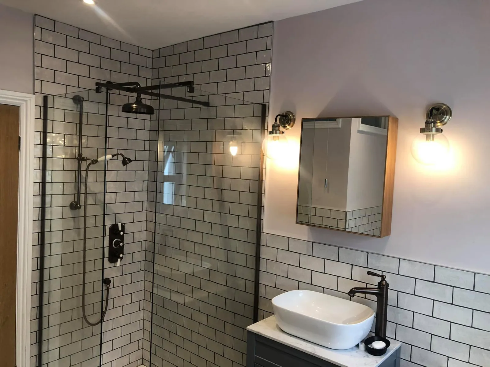 Bathroom installation by Space B Tiling: walk-in shower with white metro tiles and black fittings