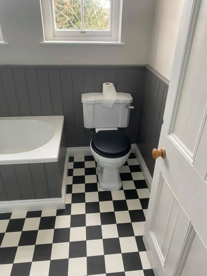 Bathroom installation by Space B Tiling: traditional toilet with grey panelling and chequered floor