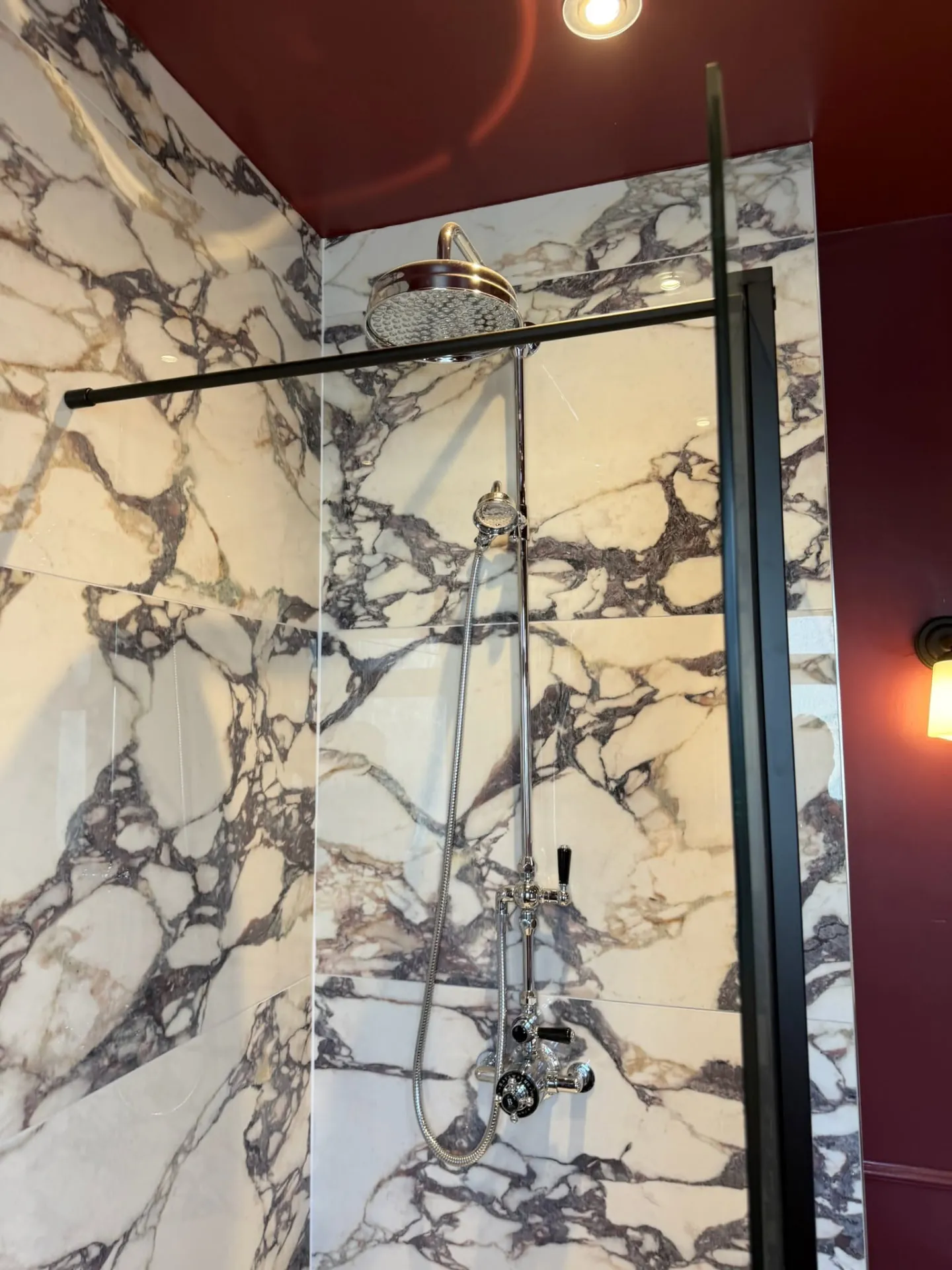 Bathroom installation by Space B Tiling: traditional chrome shower with bold marble-effect tiles