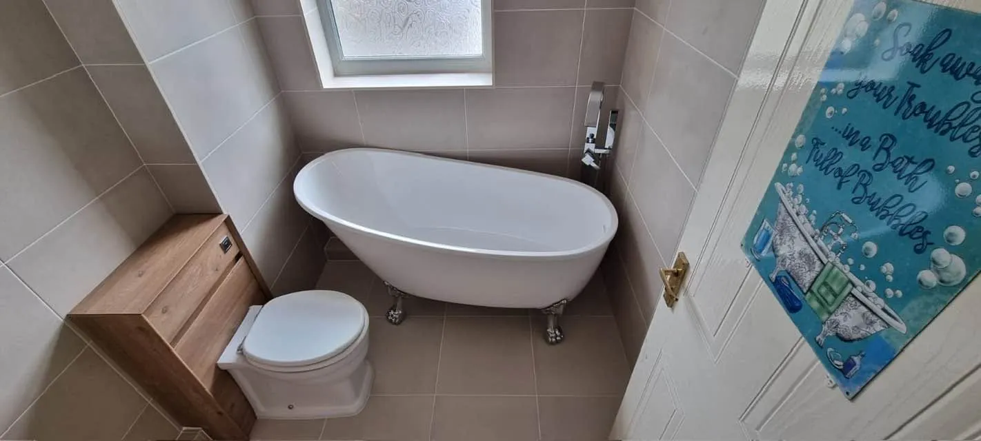 Bathroom installation by Space B Tiling: freestanding bath with wooden storage unit