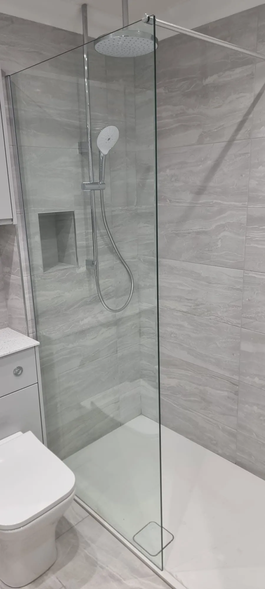 Bathroom installation by Space B Tiling: walk-in shower with marble-effect tiles and built-in niche