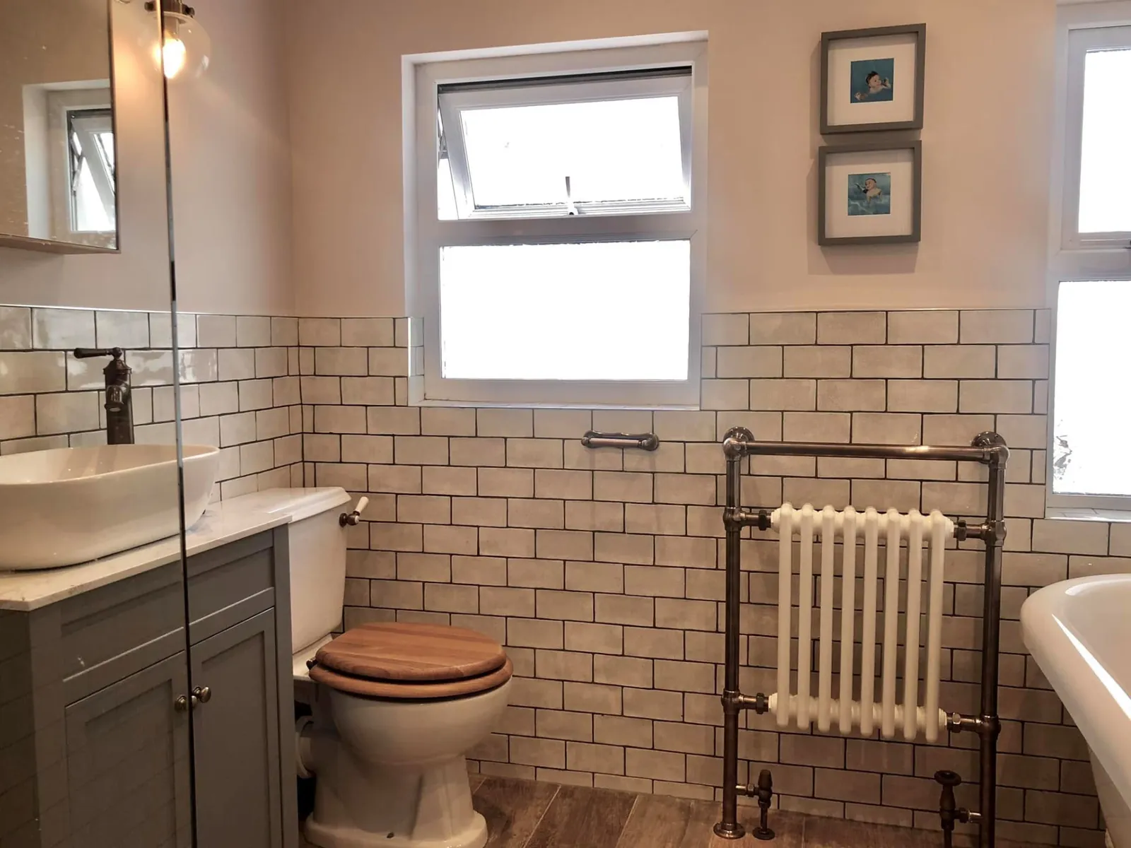 Bathroom installation by Space B Tiling: white metro tiles, vanity unit and traditional towel radiator