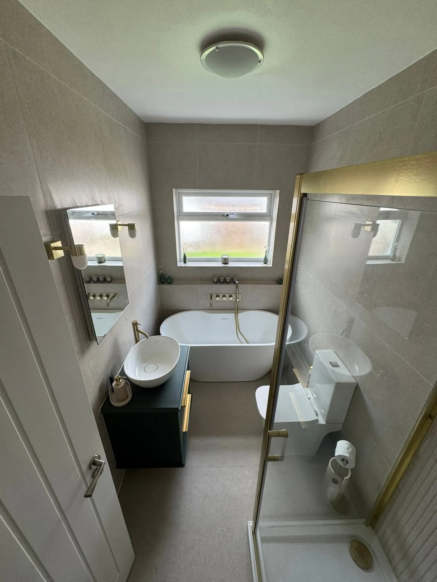 Bathroom installation by Space B Tiling: freestanding bath, green vanity and brushed brass fittings