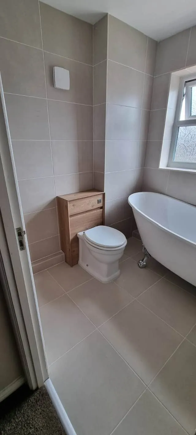 Bathroom installation by Space B Tiling: freestanding bath in a light neutral tiled bathroom