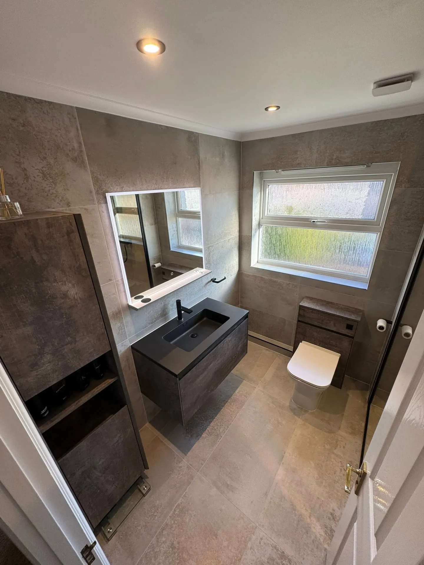 Bathroom installation by Space B Tiling: contemporary dark vanity with taupe tiles