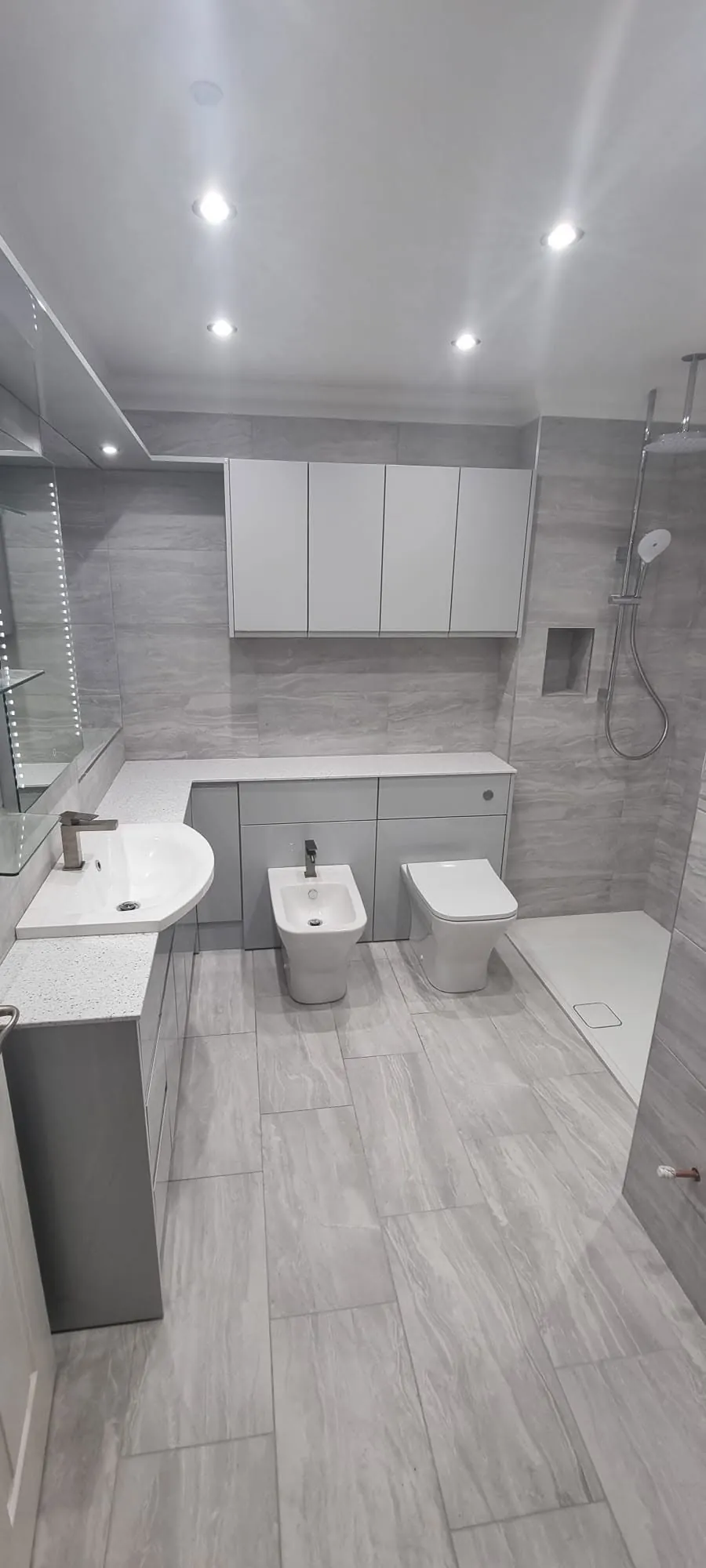 Bathroom installation by Space B Tiling: large grey and white bathroom with shower and vanity