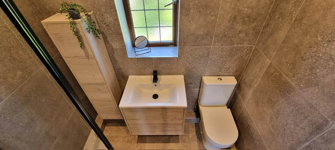 Bathroom installation by Space B Tiling: vanity and toilet among stone-effect tiles